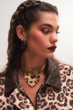 Μοντέλο φοράει τα σκουλαρίκια Heart Inferno FunkDaQueen από ατσάλι με μαύρη καρδιά και χρυσές φλόγες