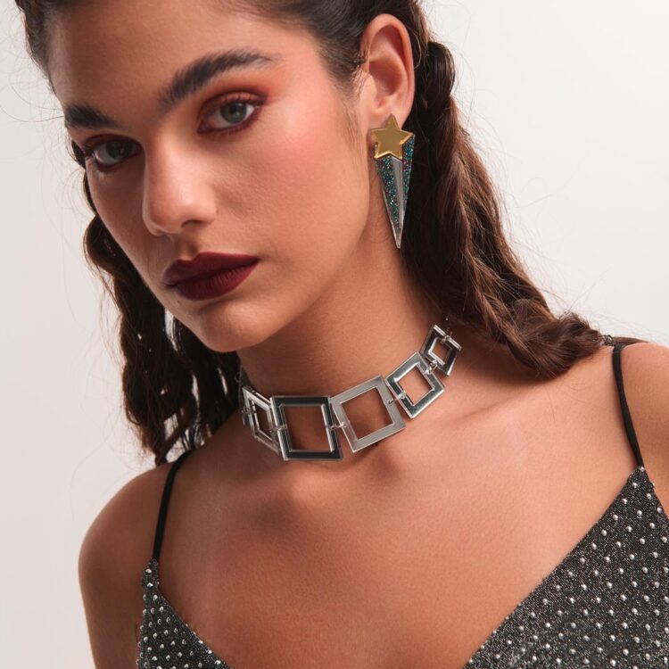 Μοντέλο φοράει τα σκουλαρίκια Cosmic Trail από plexiglass σε σχέδιο αστέρι με χρυσή και γκλίτερ λεπτομέρεια, δημιουργία της FunkDaQueen.