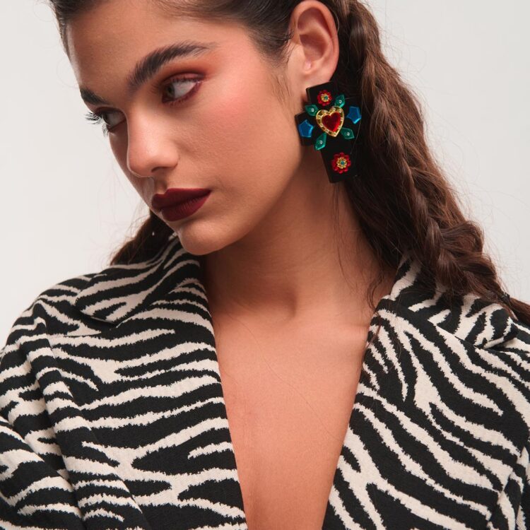 Μοντέλο φοράει σκουλαρίκια plexiglass Crossbeat FunkDaQueen σε σχήμα σταυρού με κόκκινη καρδιά στο κέντρο