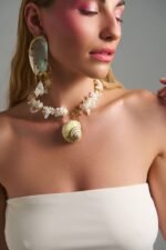 Thalassa Earrings ασύμμετρα σκουλαρίκια με φυσικό κοχύλι, αλυσίδες και πέρλες φορεμένα σε μοντέλο