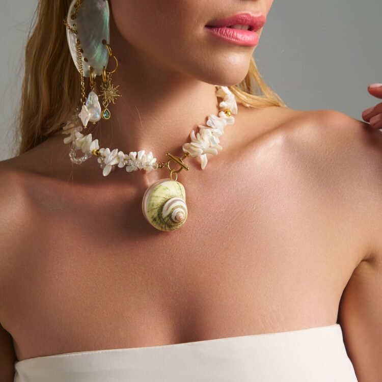 Thalassa Earrings ασύμμετρα σκουλαρίκια με φυσικό κοχύλι, αλυσίδες και πέρλες φορεμένα σε μοντέλο