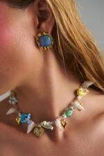 Model wearing Cobalt Blue Earrings with deep blue stone and hammered gold frame