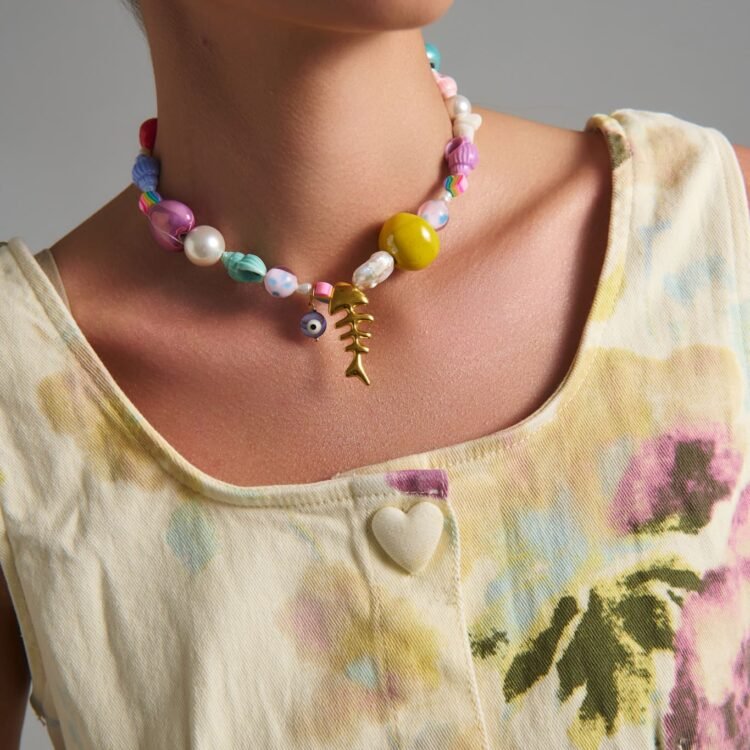 Χειροποίητο πολύχρωμο κολιέ Treasure με fishbone charm, πέρλες και pastel χάντρες φορεμένο από μοντέλο