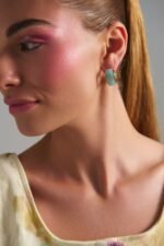 Model wearing Riviera Hoops Mint earrings with glossy mint finish and gold details