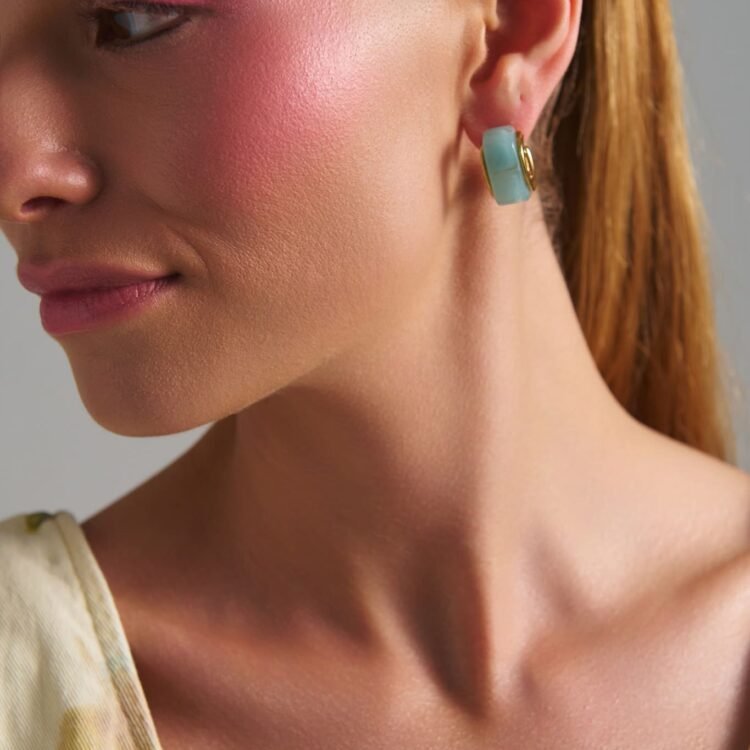 Model wearing Riviera Hoops Mint earrings with glossy mint finish and gold details