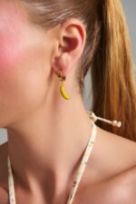 Banana Mood Earrings gold banana hoop earrings worn on model