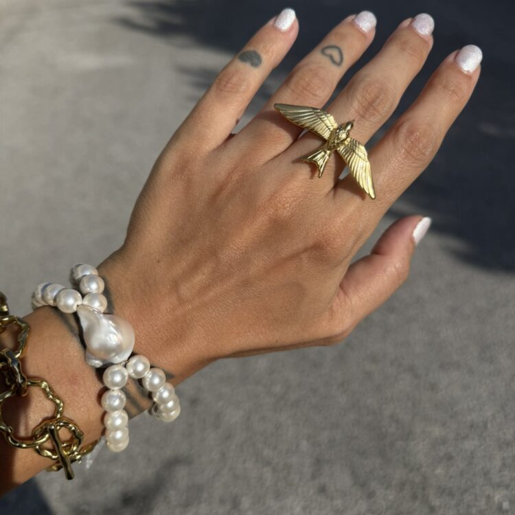 Stainless steel bird ring with flying swallow design.