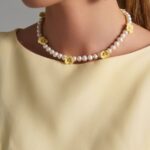 Handmade freshwater pearl necklace with yellow ceramic flowers.
