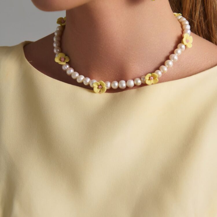 Handmade freshwater pearl necklace with yellow ceramic flowers.