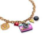 Vintage-inspired gold-tone necklace with miniature camera, compass, heart and decorative charms