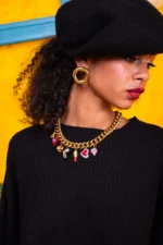 Gold-tone statement charm necklace with red and pink hearts, miniature teddy bear and decorative pendants