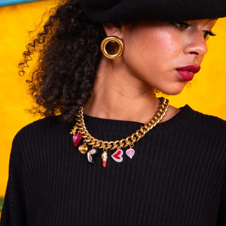 Gold-tone statement charm necklace with red and pink hearts, miniature teddy bear and decorative pendants